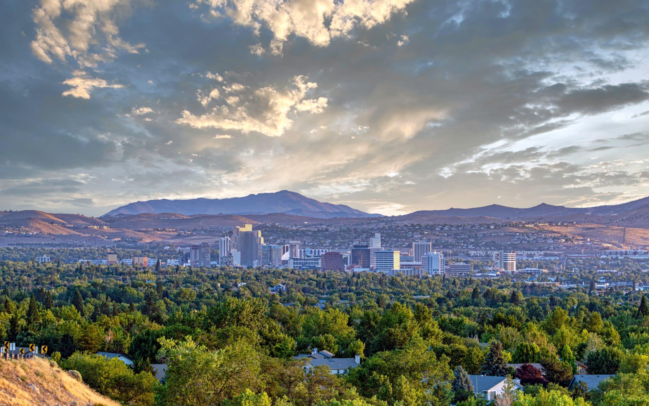 Reno skyline with mountains and clouds at sunset.