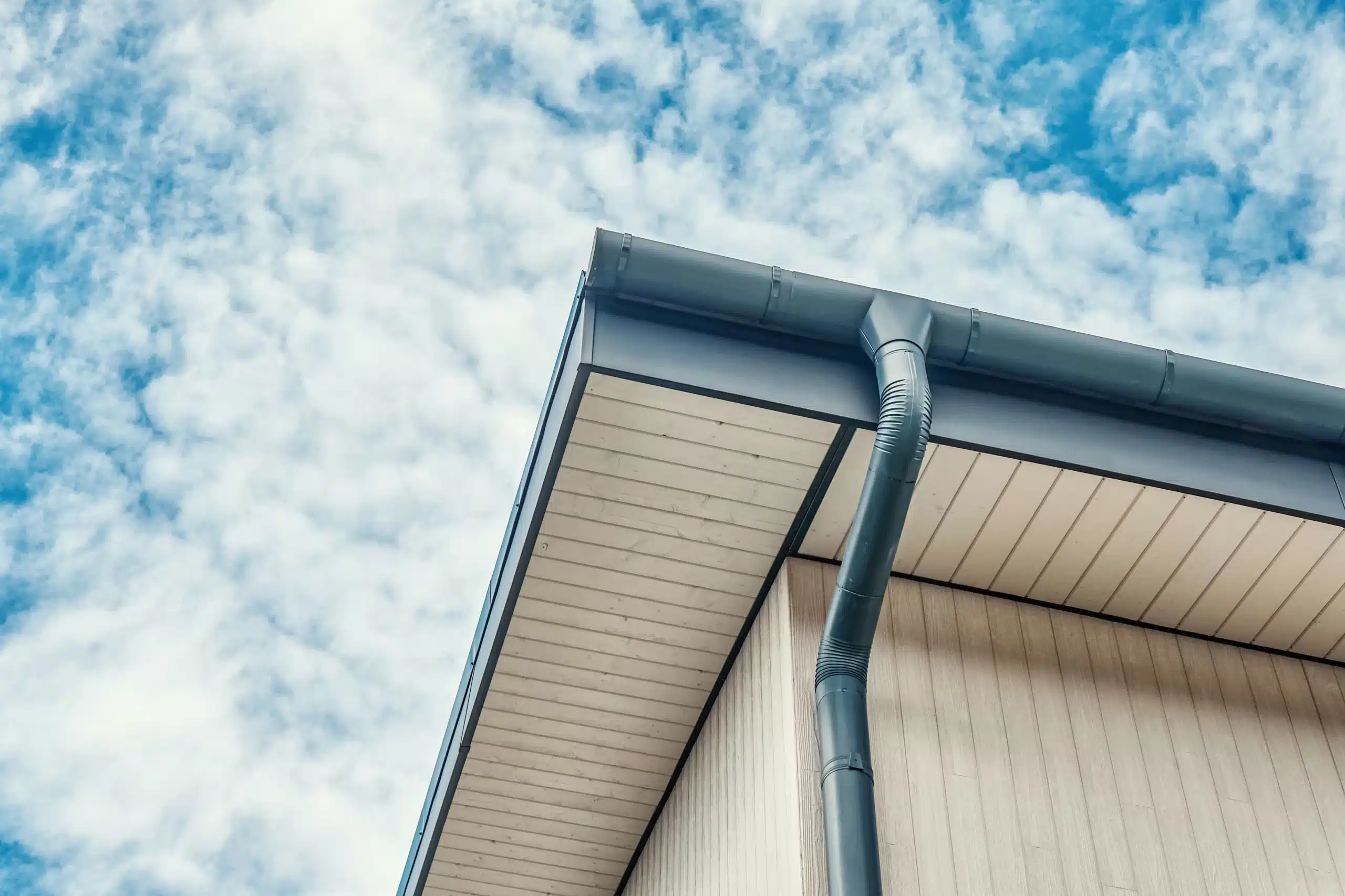 Seamless gutter and downspout against a bright Nevada sky