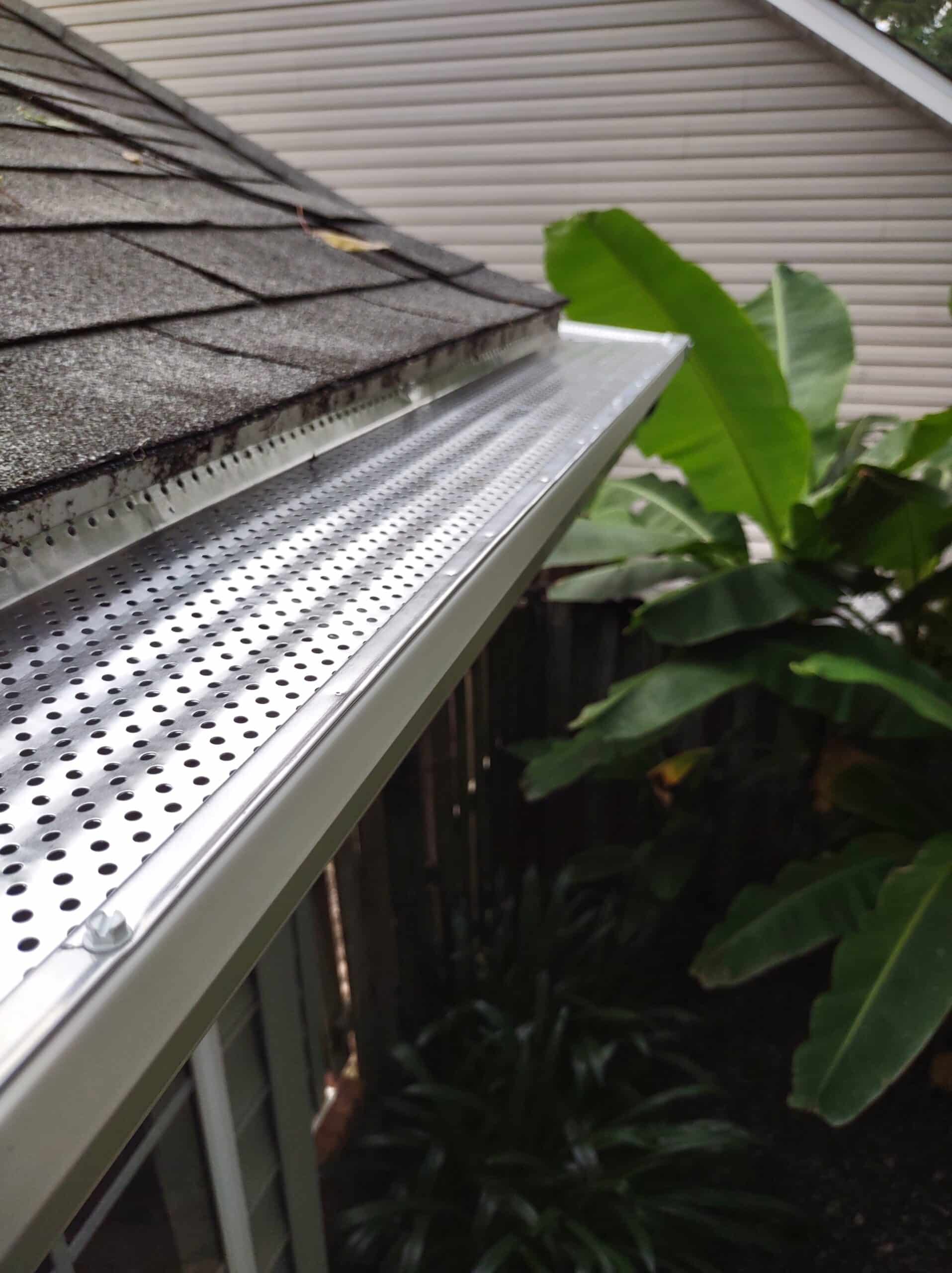 Perforated metal leaf guard installed over a seamless gutter