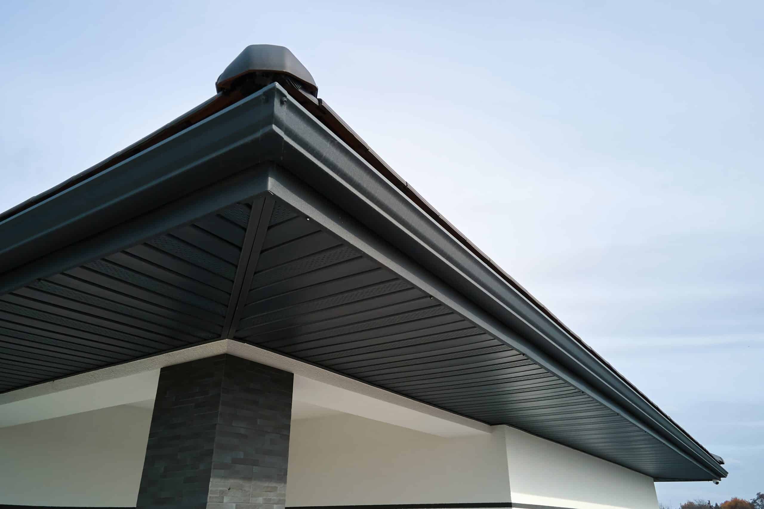 Black seamless gutter installed below a dark soffit
